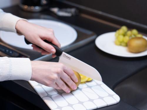 a person holding a knife on a cutting board at Tokyu Stay Aoyama Premier in Tokyo