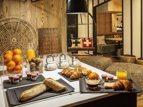 a table with a tray of bread and pastries on it at Mercure Chambéry Centre in Chambéry