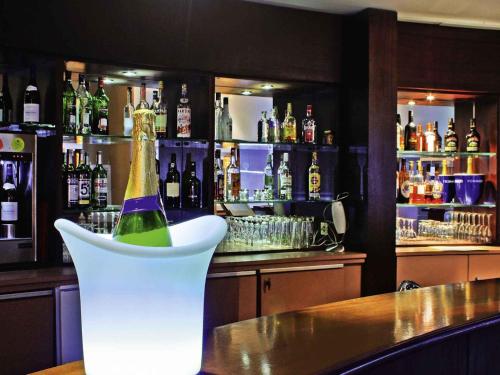 a bottle of champagne sitting on a counter in a bar at Mercure Chambéry Centre in Chambéry
