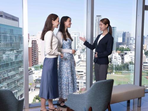 a group of three women standing in front of a window at Tokyu Stay Aoyama Premier in Tokyo