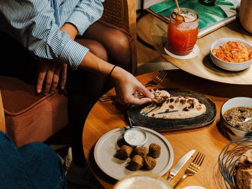 a person sitting at a table with a plate of food at Mercure La Roche Sur Yon in La Roche-sur-Yon