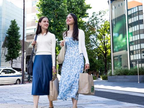 two women walking down the street with shopping bags at Tokyu Stay Aoyama Premier in Tokyo