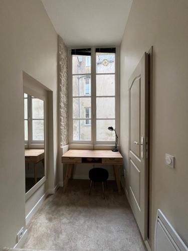 a room with a wooden desk in front of a window at Le Nid in Nantes