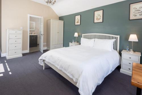 a bedroom with a large white bed and blue walls at Salty Dog Restaurant, Pub & Guesthouse in Ballycotton