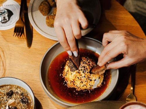 a person eating food in a bowl on a table at Mercure La Roche Sur Yon in La Roche-sur-Yon
