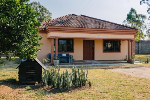 a small house in a field with a yard at Tubungu- House of Lux& Lush in Matsapha