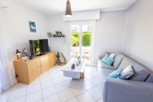a living room with a couch and a tv at LE LEMAN - 5 min à pieds du lac, des plages, des parcs in Publier