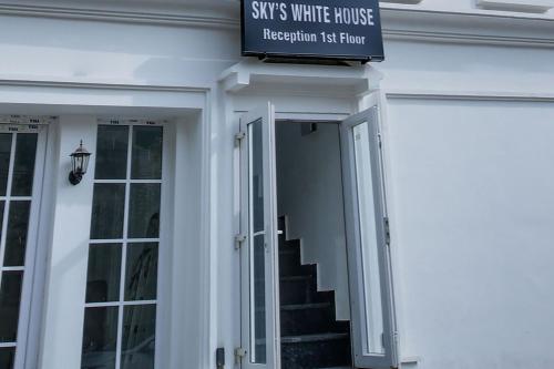 a sign on the side of a white house at Hotel O Sky White House in Ludhiana