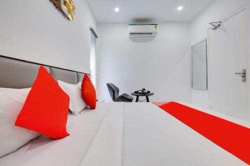 a bedroom with red and white pillows on a bed at Hotel O Sky White House in Ludhiana