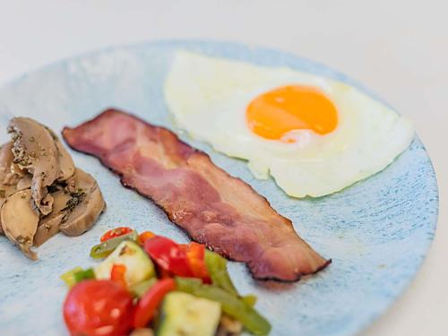 セトゥーバルにあるノボテル セトゥバルのベーコン、卵、野菜が添えられた料理