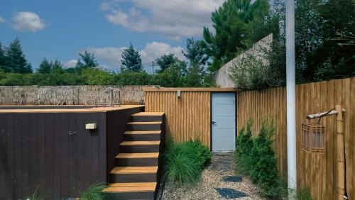 a garden with a wooden fence with a staircase and a door at The X10 Nordic Tent and Glamping Pool Villa Khaoyai เขาใหญ่ - SHA Certified in Ban Thung Sawang