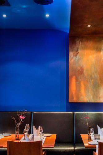 a dining room with two tables and a painting on the wall at Mintrops Stadt Hotel Margarethenhöhe in Essen