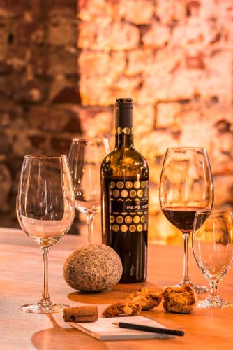 a bottle of wine and three wine glasses on a table at Mintrops Stadt Hotel Margarethenhöhe in Essen