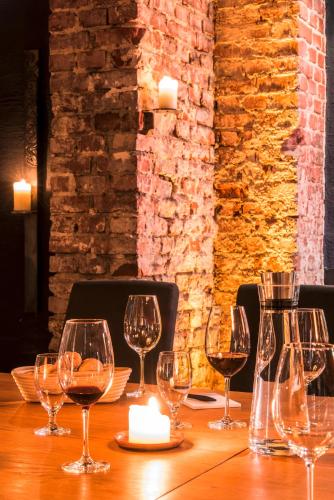 a table with wine glasses and a candle on it at Mintrops Stadt Hotel Margarethenhöhe in Essen