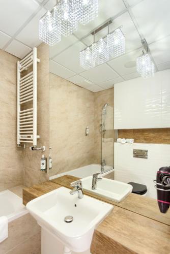 a bathroom with a sink and a mirror at Apartamenty Vola Residence in Warsaw