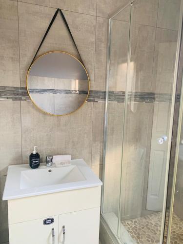a bathroom with a sink and a shower with a mirror at Tubungu- House of Lux& Lush in Matsapha