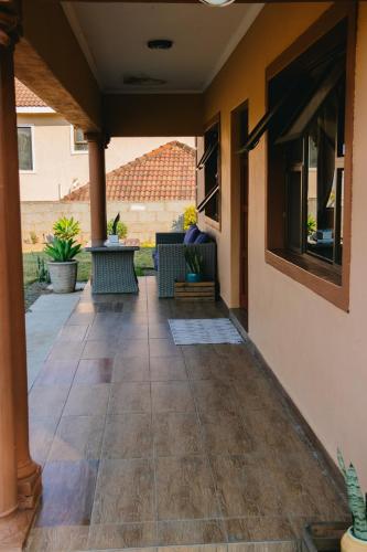 an outdoor patio with benches on a house at Tubungu- House of Lux& Lush in Matsapha