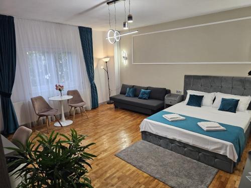 a bedroom with a large bed and a couch at Home Dulcesa in Sibiu