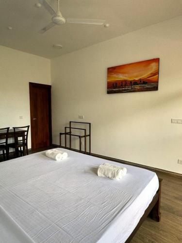 a bedroom with a bed with two white towels on it at Niyanca Guest in Beruwala