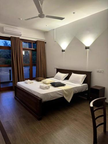 a bedroom with a large bed with a ceiling fan at Niyanca Guest in Beruwala