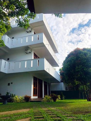 a white building with stairs on the side of it at Niyanca Guest in Beruwala