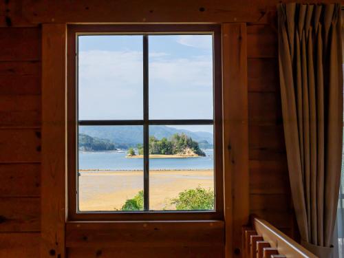 a window in a room with a view of a beach at Villa & Sauna - NAGIOTO - in Kure
