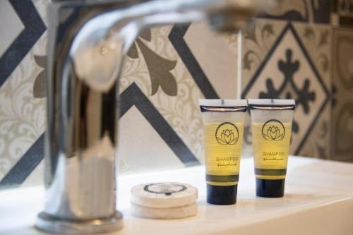 two cups sitting on a sink next to a faucet at شقق فينا in Khamis Mushayt