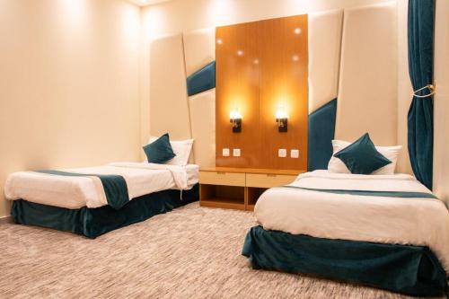 a hotel room with two beds and a mirror at شقق فينا in Khamis Mushayt