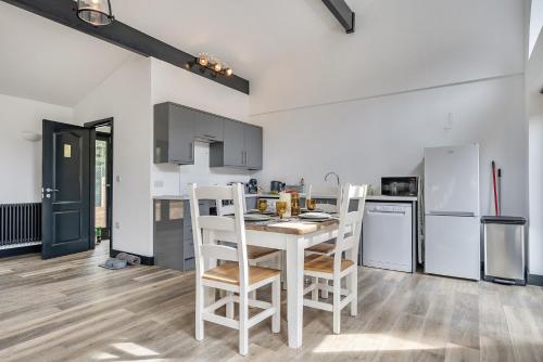 a kitchen with a white table and chairs and appliances at The Annex in Wimborne Minster