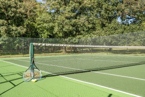 a tennis racket and balls on a tennis court at The Annex in Wimborne Minster