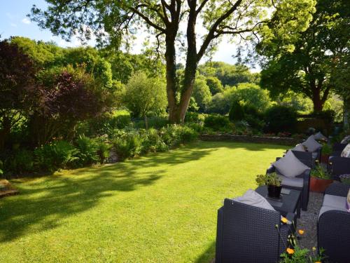 a garden with a lawn with chairs and trees at 3 Bed in Cenarth 79198 in Felindre