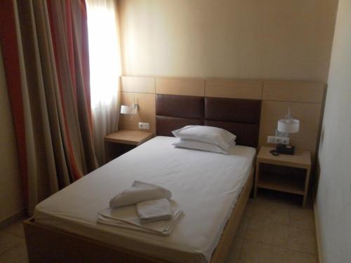 a bedroom with a bed with two towels on it at Esperia in Thessaloniki