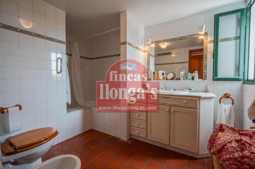 a bathroom with a toilet and a sink and a mirror at Villa independiente con acceso a la playa in Son Xoriguer