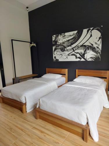 two beds sitting next to each other in a bedroom at Mercusuar Resort Jepara in Kesembu
