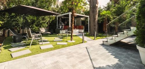 a patio with a bunch of chairs and an umbrella at BS Milla Estate Heidelberg in Heidelberg