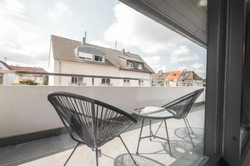 a balcony with two chairs and a table and a window at BS Milla Estate Heidelberg in Heidelberg