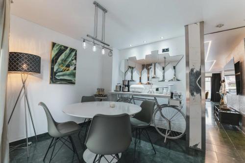 a dining room with a white table and chairs at BS Milla Estate Heidelberg in Heidelberg