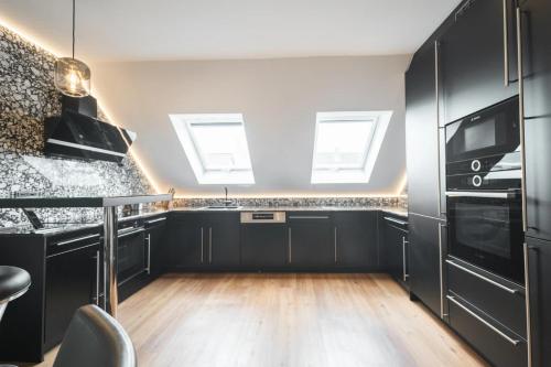 a kitchen with black cabinets and black appliances at BS Milla Estate Heidelberg in Heidelberg