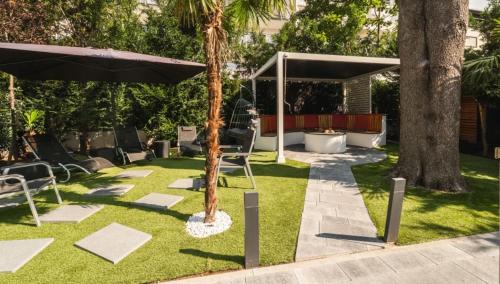 a garden with chairs and an umbrella on the grass at BS Milla Estate Heidelberg in Heidelberg