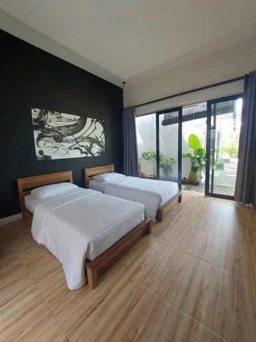 a bedroom with two beds and a large window at Mercusuar Resort Jepara in Kesembu