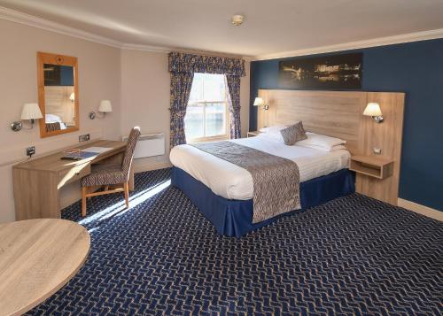 a hotel room with a bed and a desk at The Queens Hotel & Victoria Cloisters Apartments in York