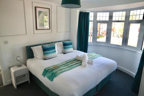 Un dormitorio con una gran cama blanca con cortinas azules. en Modern Spacious 3BR-Free Parking-Long Stay Discounts, en Maidstone