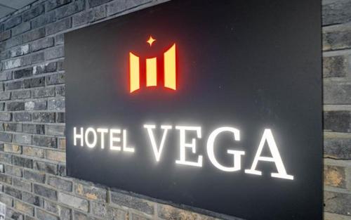 a hotel vegas sign on a brick wall at 베가호텔 in Pup'yŏng-yŏk