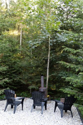 three black chairs sitting in front of a stove at Moho Будинки для відпочинку in Bukovel