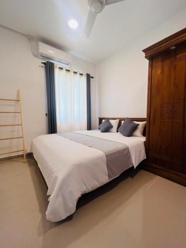 a bedroom with a large bed with a wooden headboard at Celestial Negombo Villa 85 in Negombo