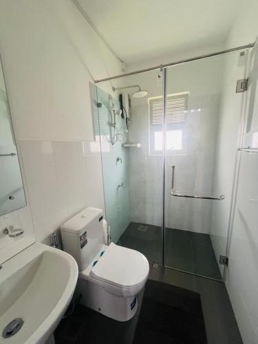 a white bathroom with a toilet and a shower at Celestial Negombo Resort Transit Stopover Villa 85 in Negombo