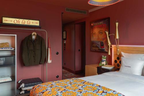 a bedroom with a bed and a coat hanging on a wall at 25hours Hotel Terminus Nord in Paris