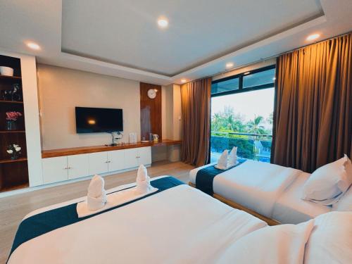a hotel room with two beds and a television at De Cairo's Mountain & Ocean View Resort 
