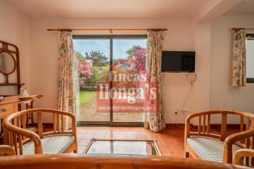 a living room with a table and chairs and a window at Villa independiente con acceso a la playa in Son Xoriguer