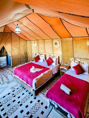 a bedroom with two beds in a tent at Original Luxury Camp in Merzouga